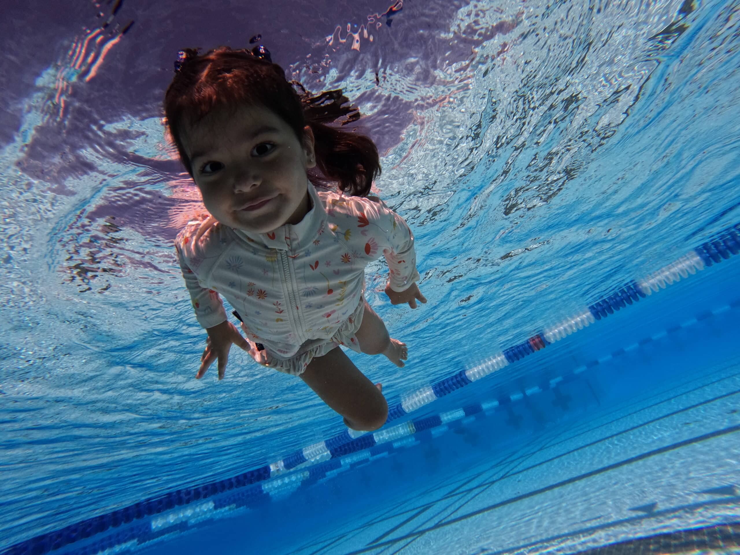 Toddler girl smiling during swim class