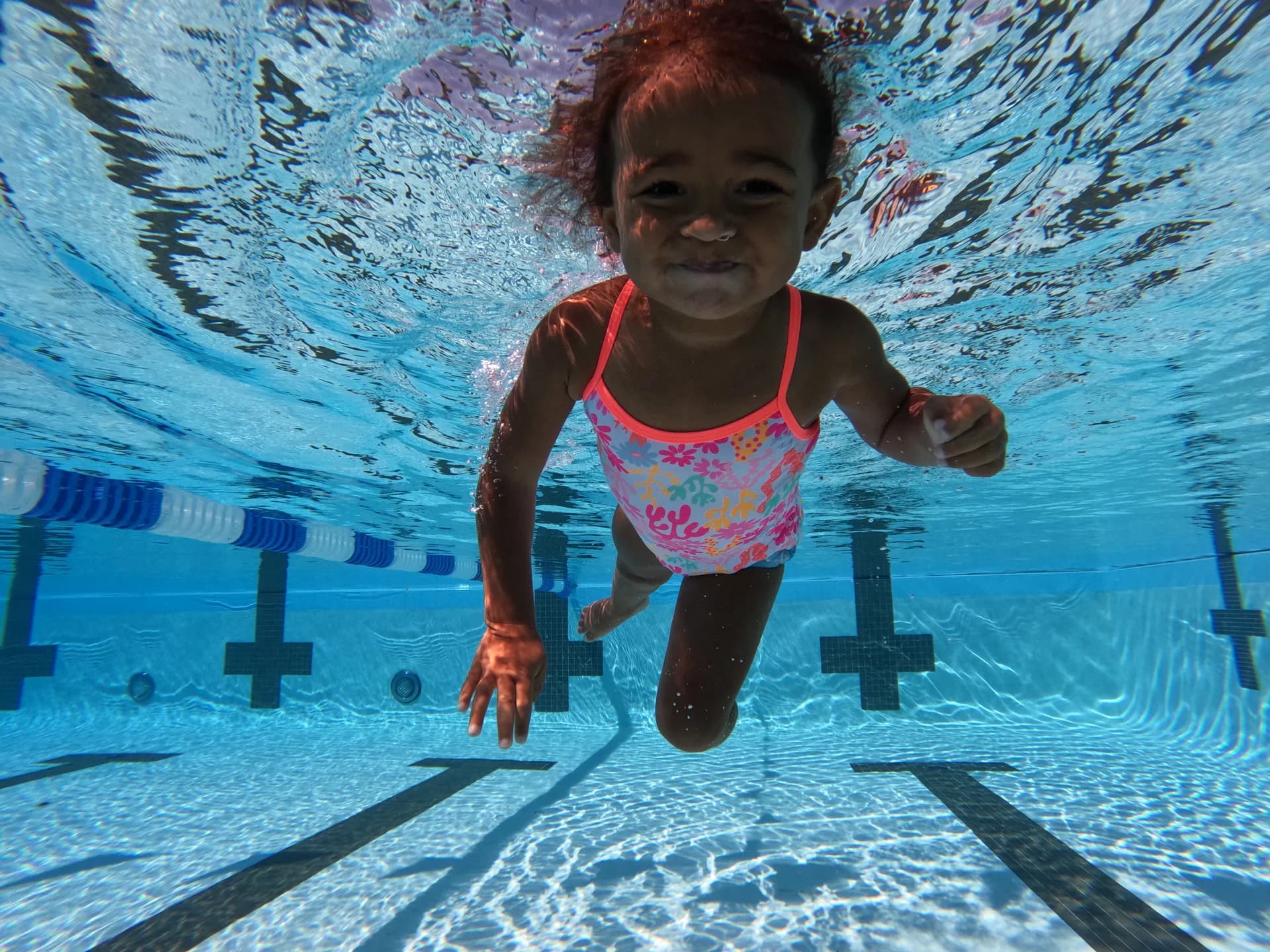 Girl in pink swimsuit learning to swim